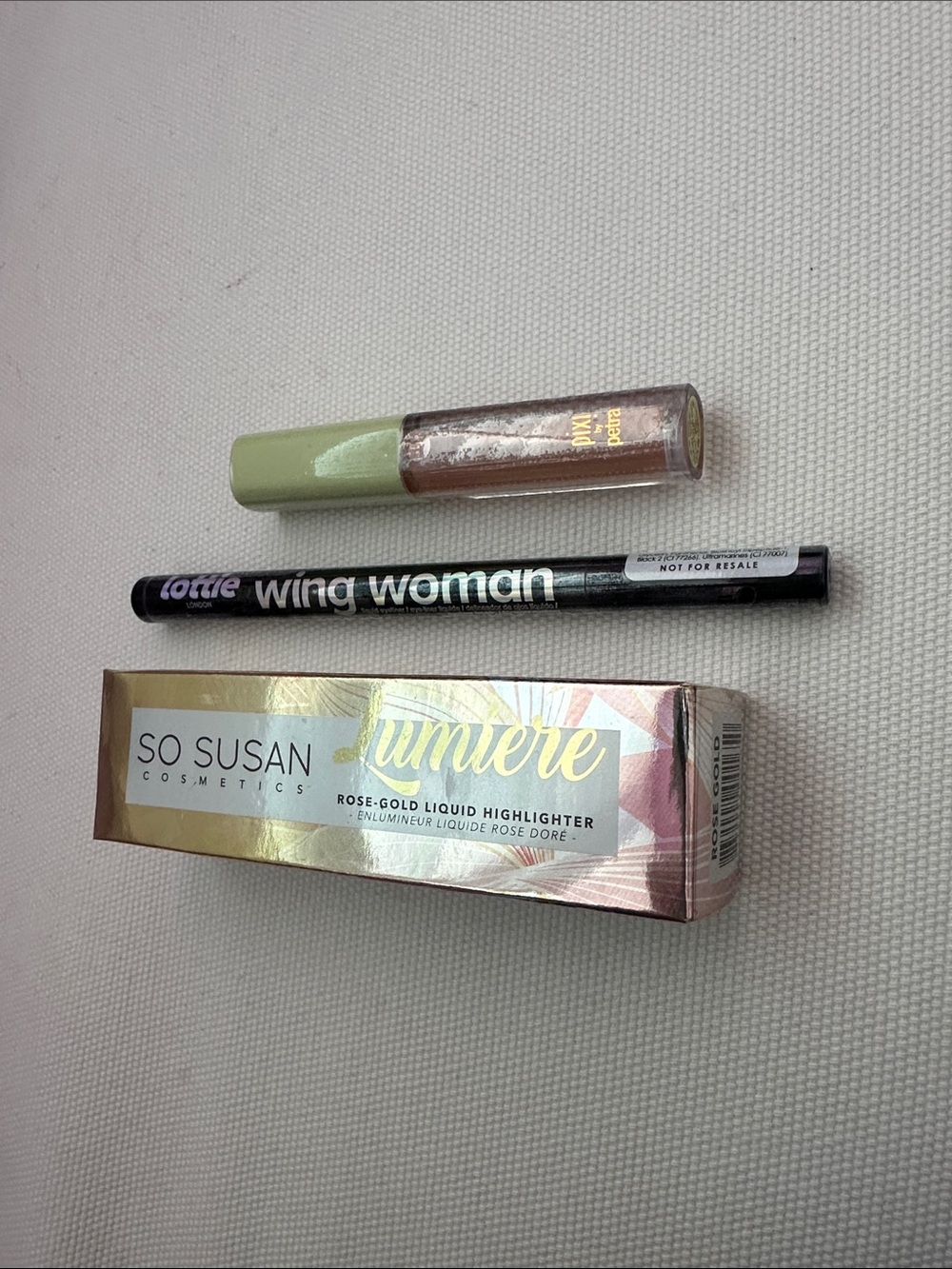 So Susan Rose-Gold Liquid Highlighter, Lottie London eyeliner, Pixi LipLift Max